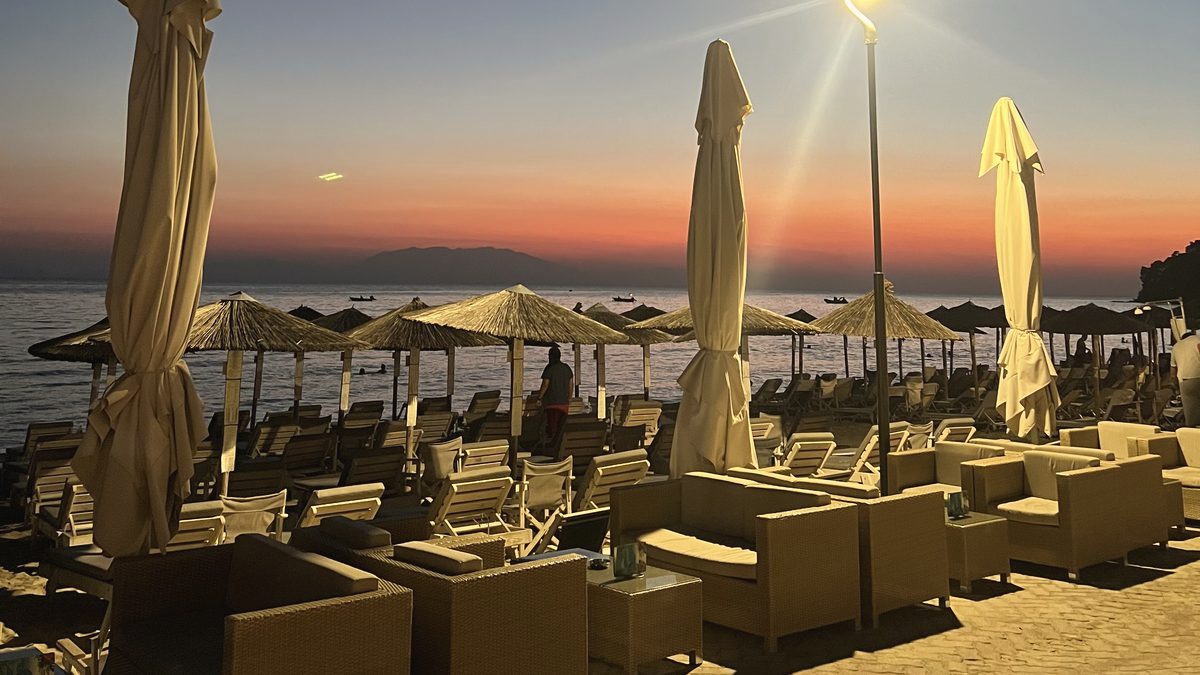 Lounge-Terrasse am Meer bei Sonnenuntergang, die Sonnenschirme geschlossen