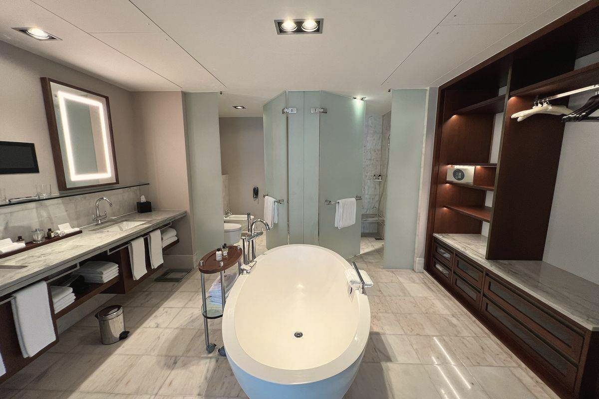 Hotelbad mit freistehender Badewanne, Doppelwaschtisch und Duschkabine
